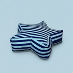 Toddler star floor pillow with navy and light blue stripes on a soft blue background, perfect for playroom decor.
